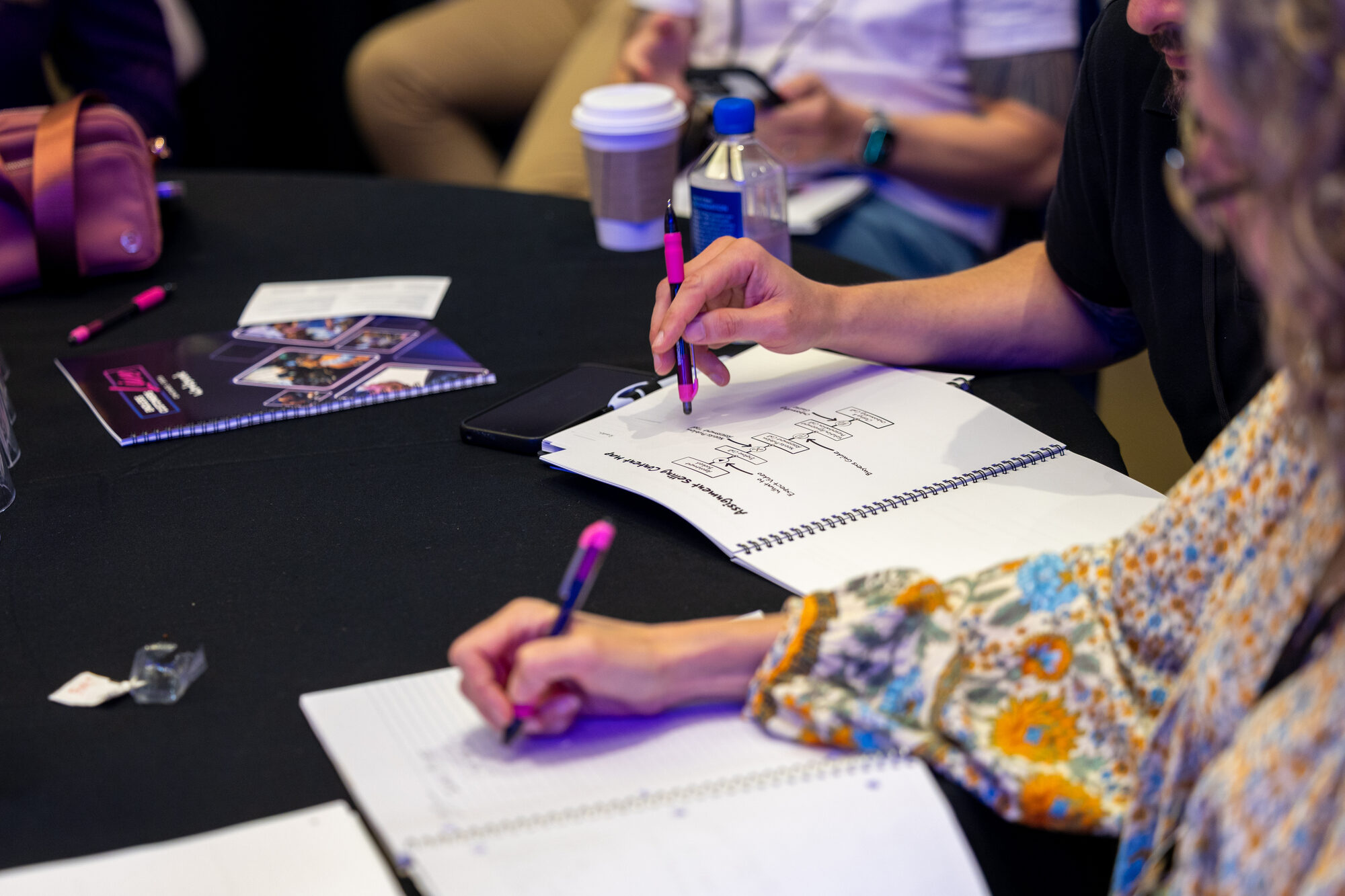 Attendees working through an exercise at a workshop table